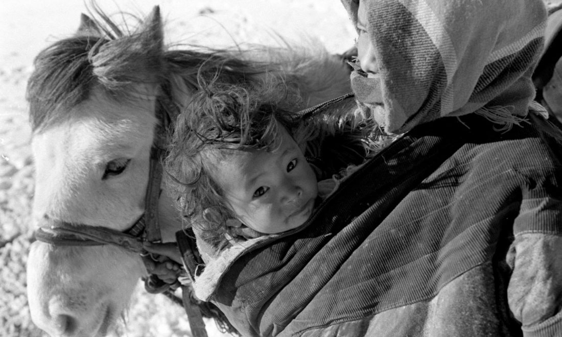 1990年3月，西藏當雄縣納木湖鄉(xiāng)三村女牧民斯卓不畏嚴寒，懷抱幼子，準備到遠處放牧。新華社記者覺果攝