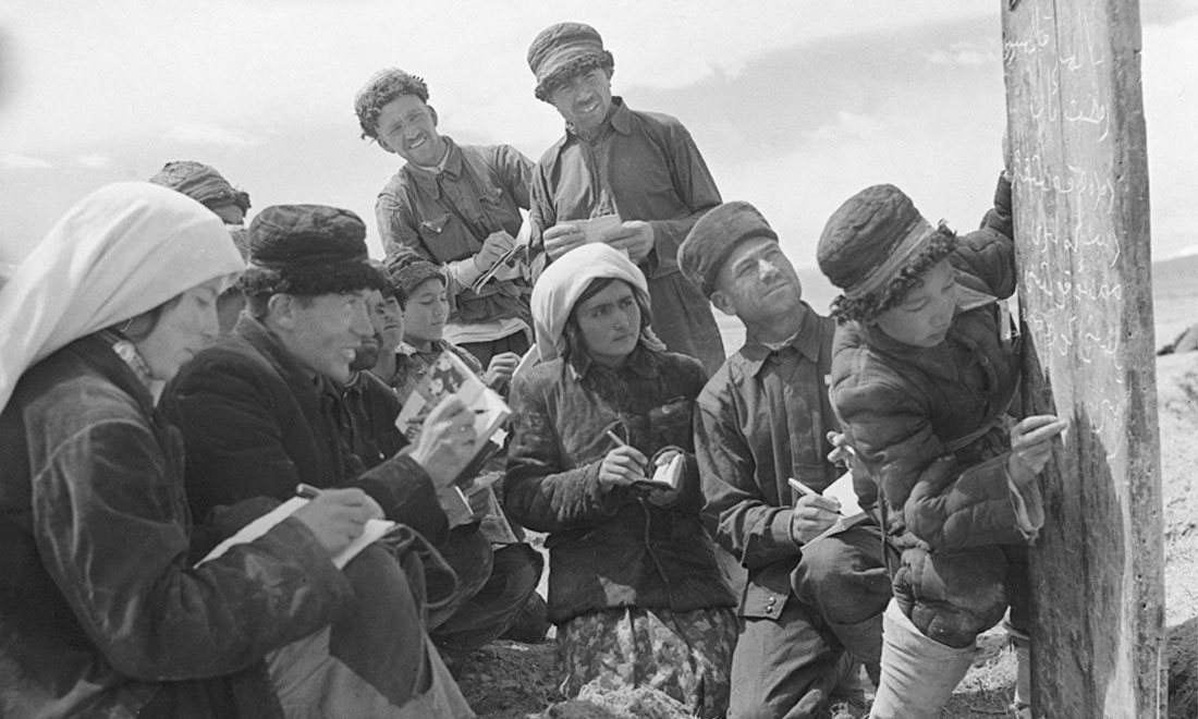 1960年6月，新疆慕士塔格峰下，大人們在小學(xué)生幫助下學(xué)習(xí)文化。新華社記者武純展攝